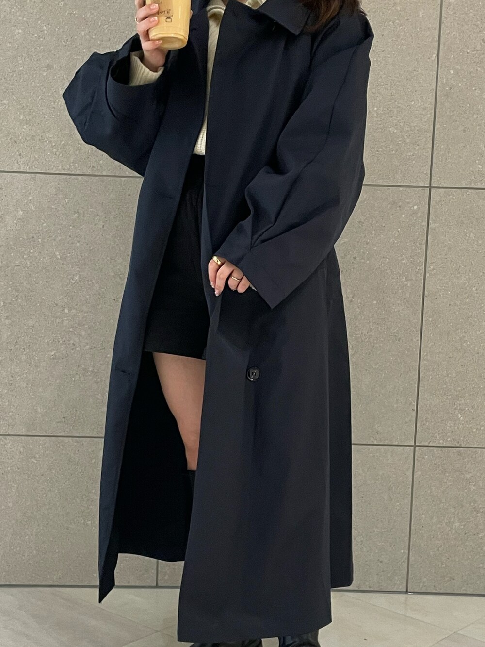 ブルー系のトレンチコート、ブラック系のブーツ、ブラック系のその他パンツを着用したレディースの春コーディネートの2枚目の写真