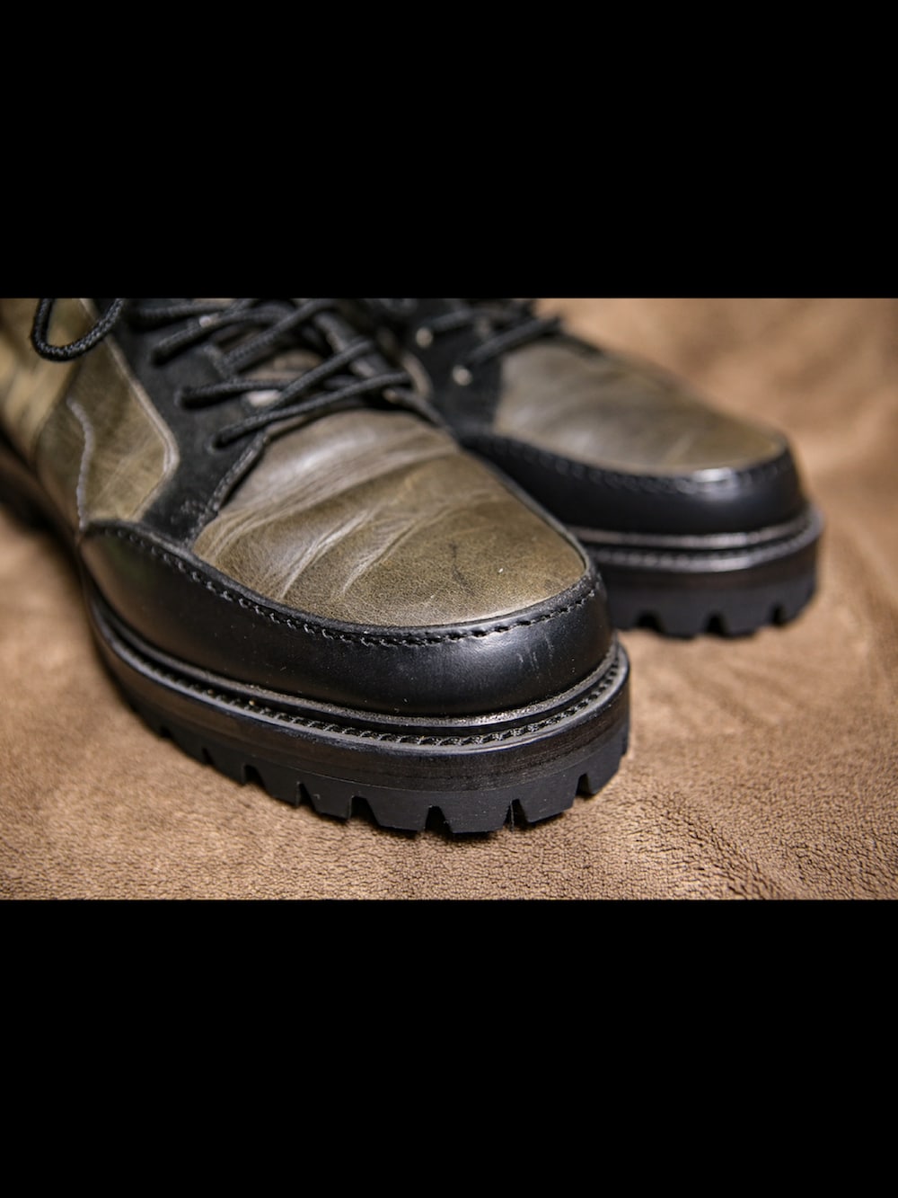 ブルー系のパーカー、ブラック系のライダースジャケット、グリーン系のカーゴパンツを着用したメンズの冬コーディネートの4枚目の写真