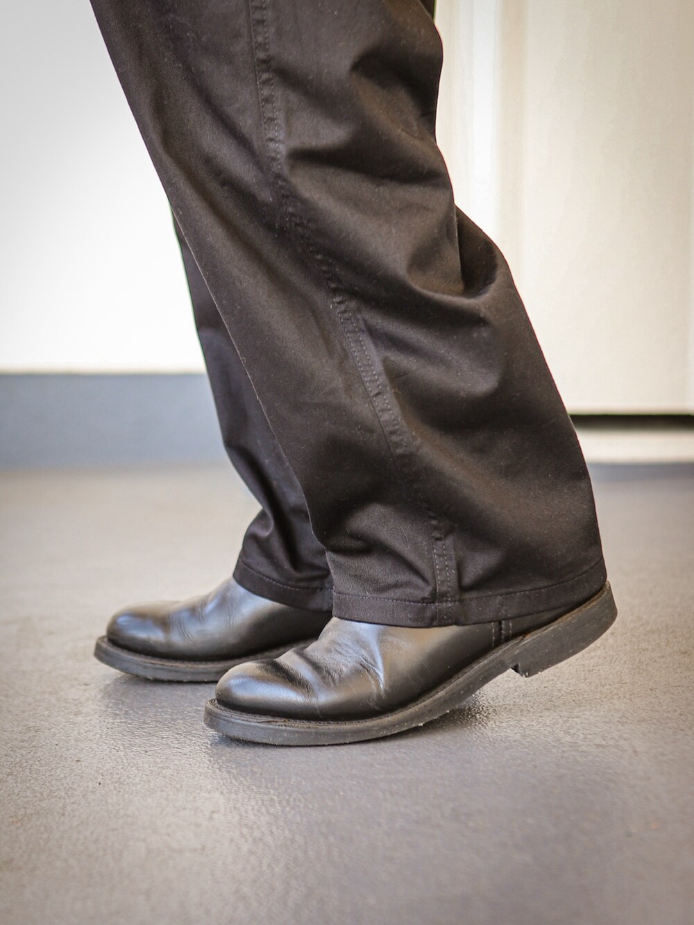 ブラック系のパーカー、ブラック系のピーコート、ブラック系のチノパンツを着用したメンズの冬コーディネートの4枚目の写真