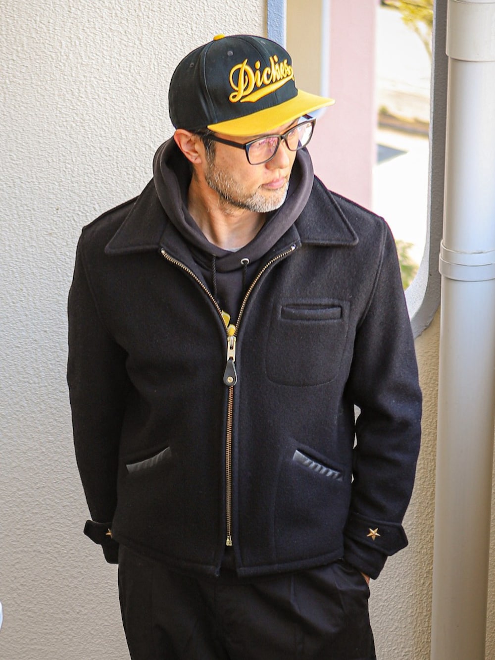 ブラック系のパーカー、ブラック系のピーコート、ブラック系のチノパンツを着用したメンズの冬コーディネートの2枚目の写真