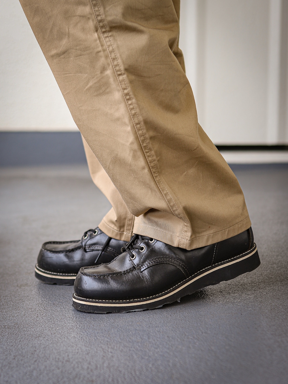 ブラック系のライダースジャケット、グレー系のパーカー、ベージュ系のチノパンツを着用したメンズの冬コーディネートの3枚目の写真