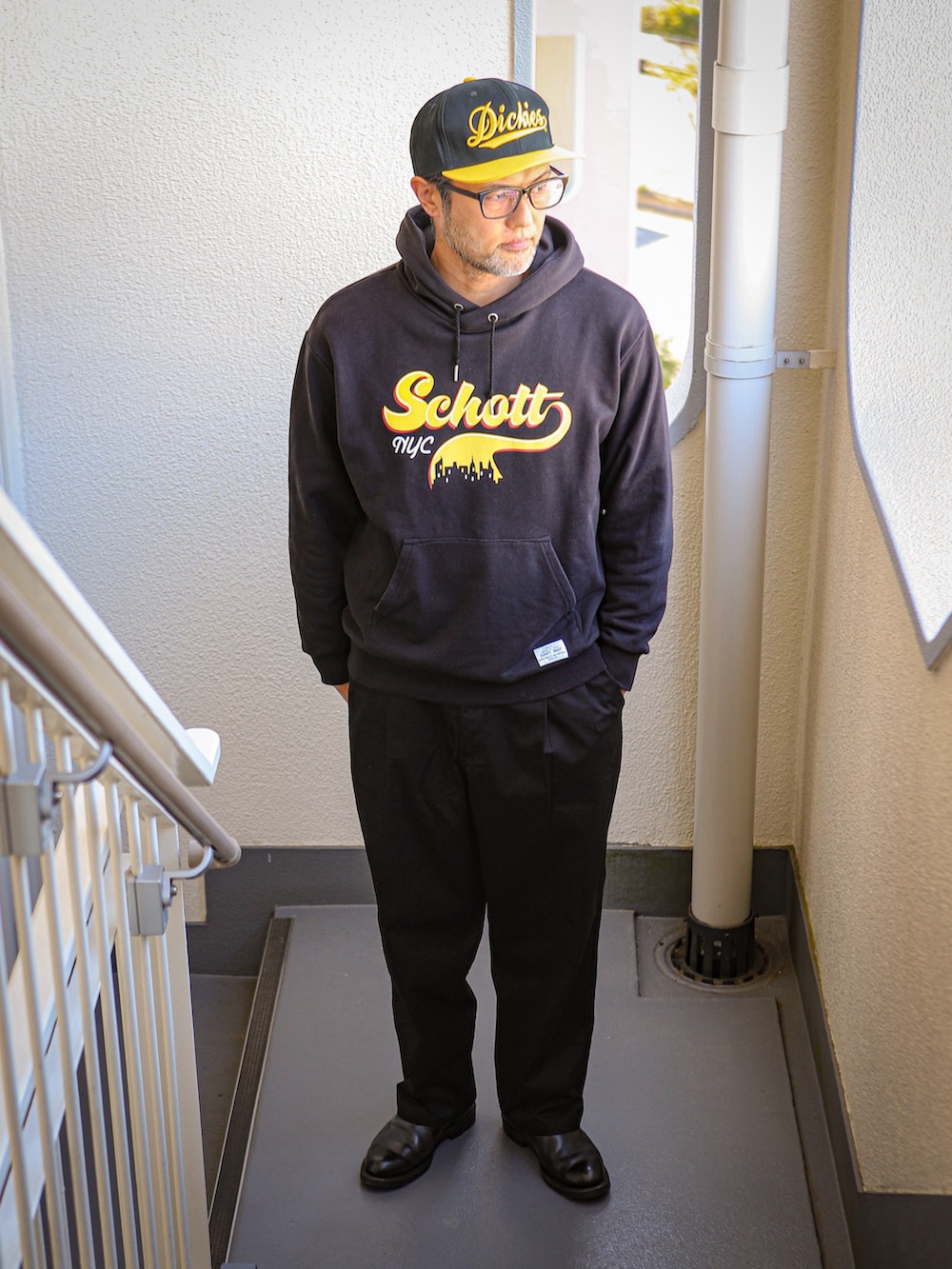 ブラック系のパーカー、ブラック系のピーコート、ブラック系のチノパンツを着用したメンズの冬コーディネートの3枚目の写真