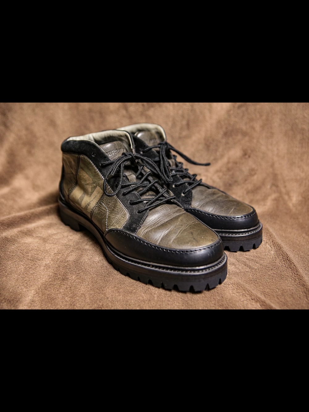 ブルー系のパーカー、ブラック系のライダースジャケット、グリーン系のカーゴパンツを着用したメンズの冬コーディネートの3枚目の写真