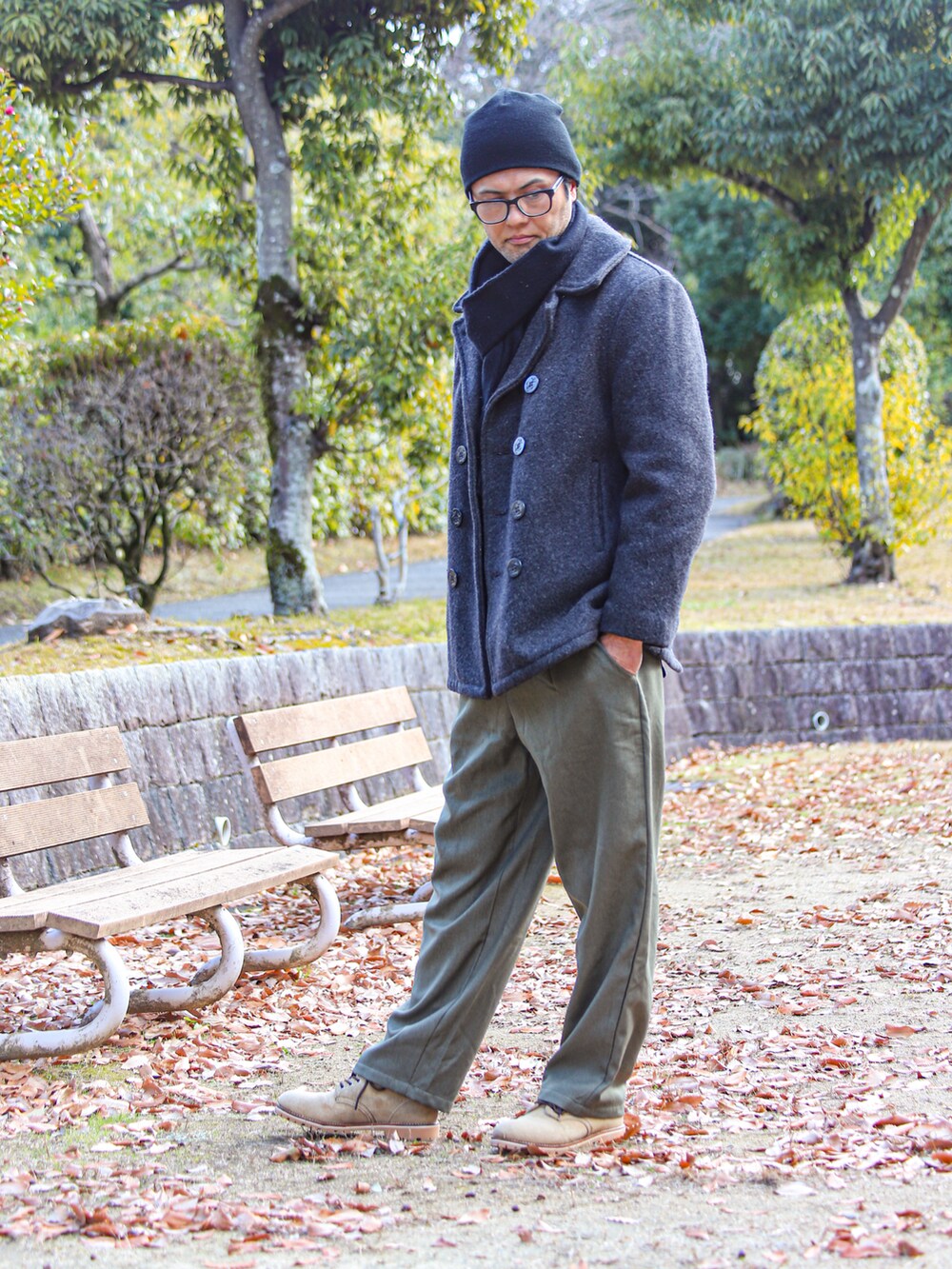 グレー系のピーコート、グリーン系のTシャツ/カットソー、グリーン系のパンツを着用したメンズの冬コーディネートの3枚目の写真