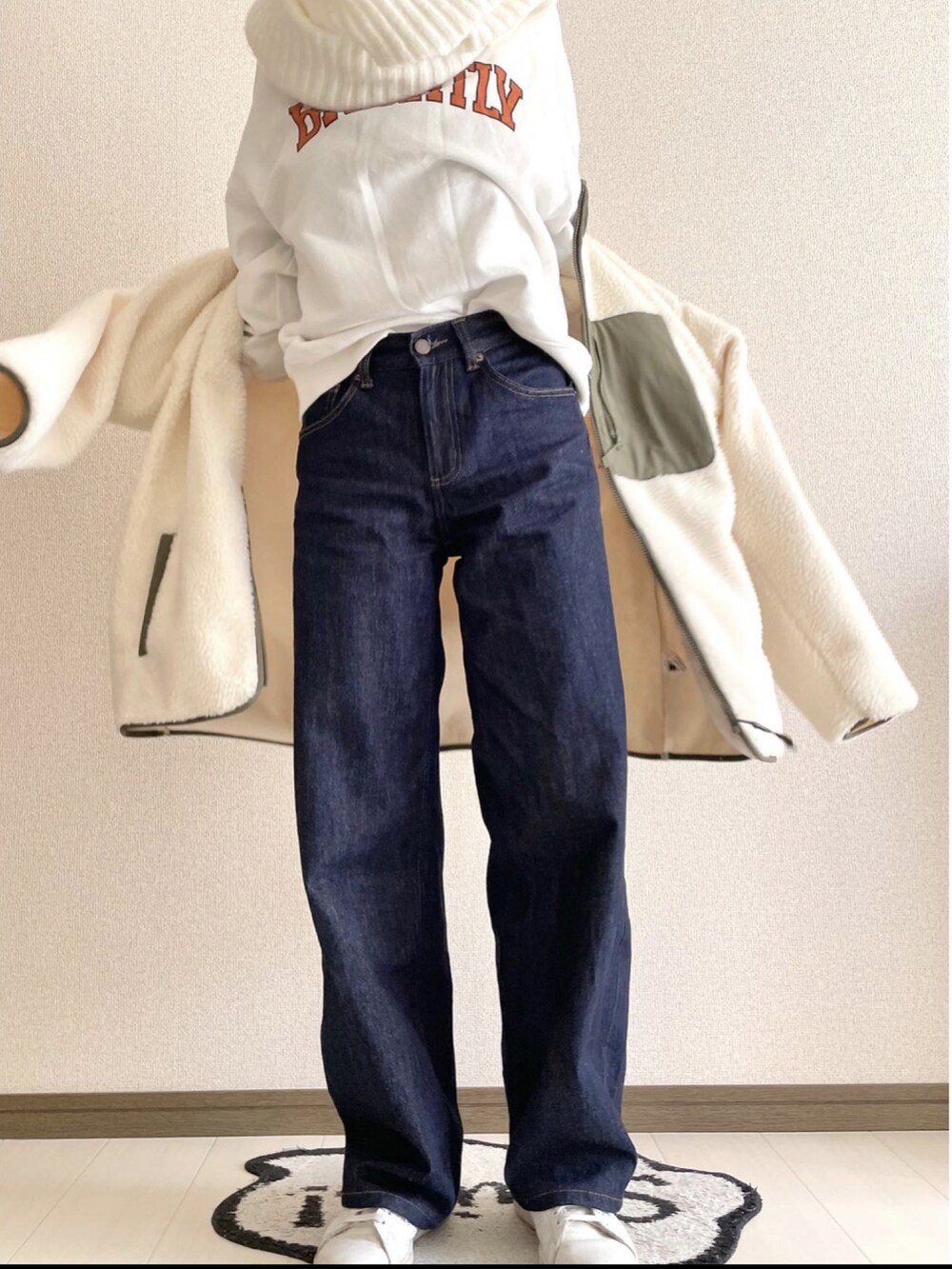 ホワイト系のスウェット、ブルー系のデニムパンツ、ホワイト系のスニーカーを着用したレディースの冬コーディネートの3枚目の写真