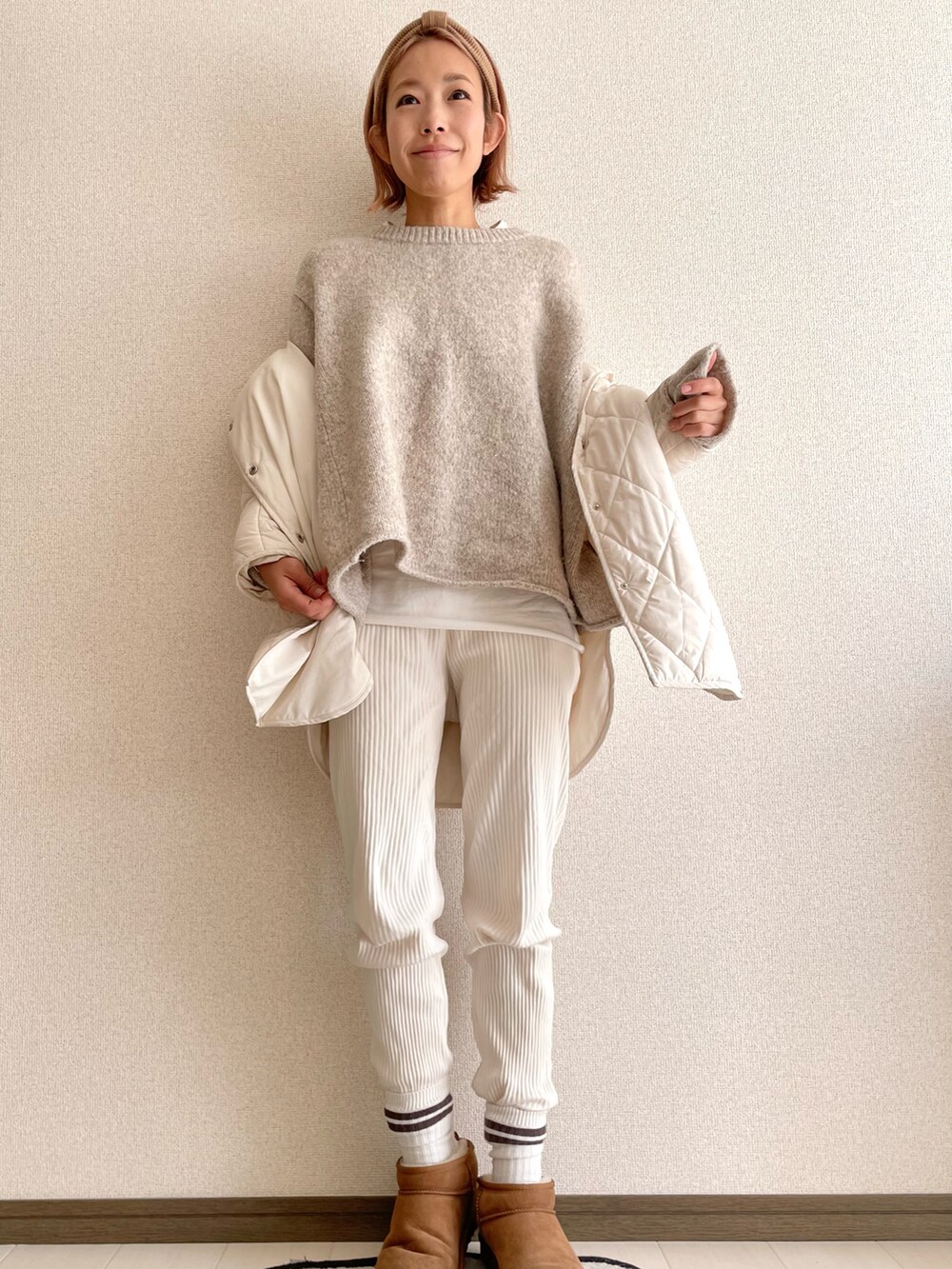 ベージュ系のニット/セーター、ホワイト系のその他パンツ、ホワイト系のダウンジャケット/コートを着用したレディースの冬コーディネートの2枚目の写真