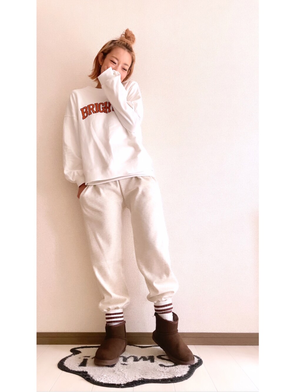 ベージュ系のスウェットパンツ、ホワイト系のスウェット、ブラウン系のブーツを着用したレディースの冬コーディネートの2枚目の写真