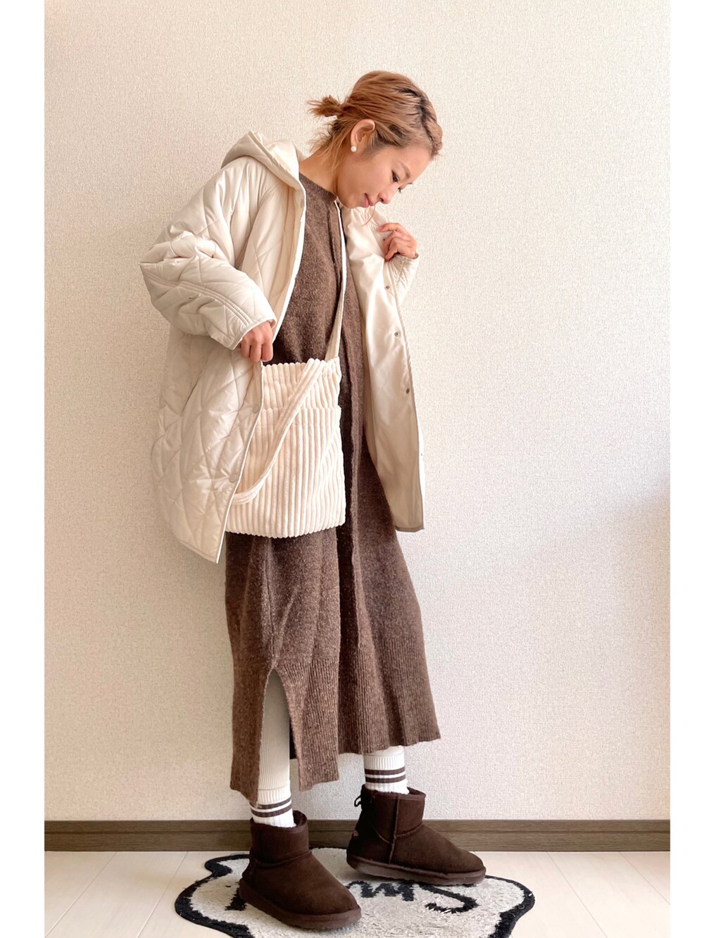 ブラウン系のワンピース、ホワイト系のショルダーバッグ、ブラウン系のブーツを着用したレディースの冬コーディネートの2枚目の写真