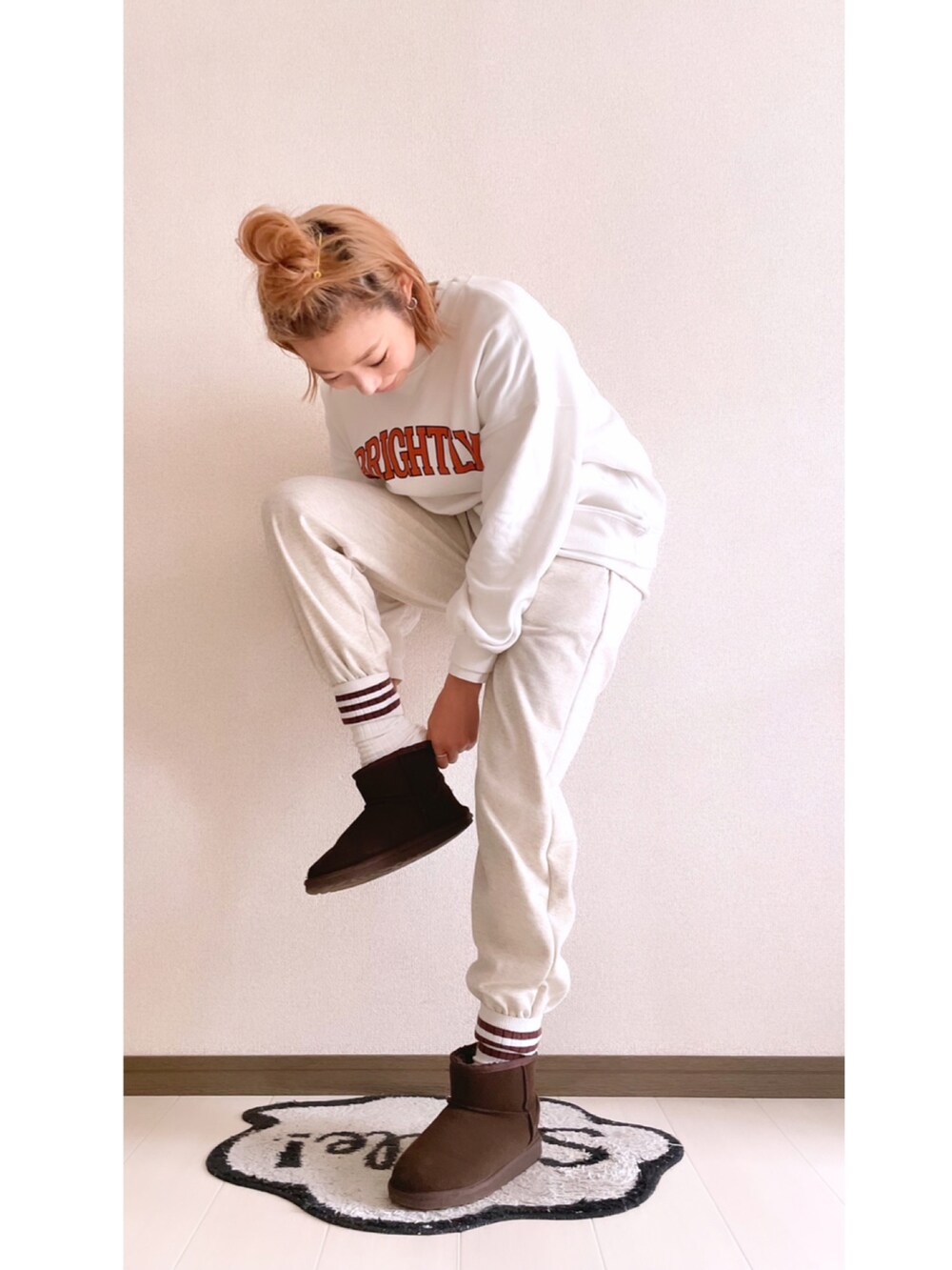 ベージュ系のスウェットパンツ、ホワイト系のスウェット、ブラウン系のブーツを着用したレディースの冬コーディネートの3枚目の写真