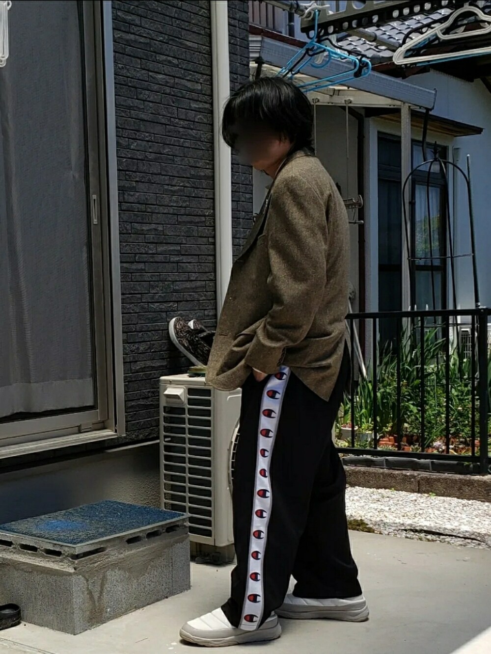 ホワイト系のスリッポン、ブラック系のパンツ、ホワイト系のTシャツ/カットソーを着用したメンズの冬コーディネートの2枚目の写真