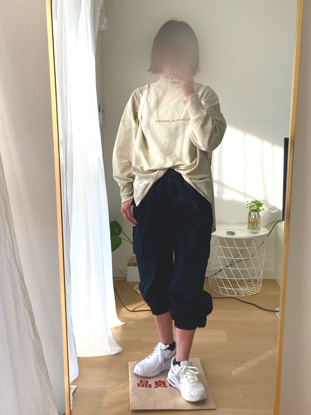 ブラック系のパンツ、ベージュ系のTシャツ/カットソー、ホワイト系のトートバッグを着用したレディースの冬コーディネートの3枚目の写真