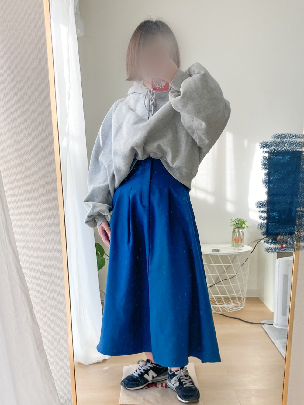 ブルー系のスカート、ブラック系のスニーカー、グレー系のパーカーを着用したレディースの冬コーディネートの2枚目の写真