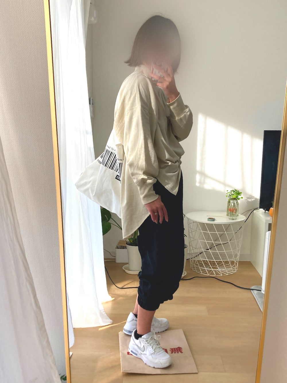 ブラック系のパンツ、ベージュ系のTシャツ/カットソー、ホワイト系のトートバッグを着用したレディースの冬コーディネートの2枚目の写真