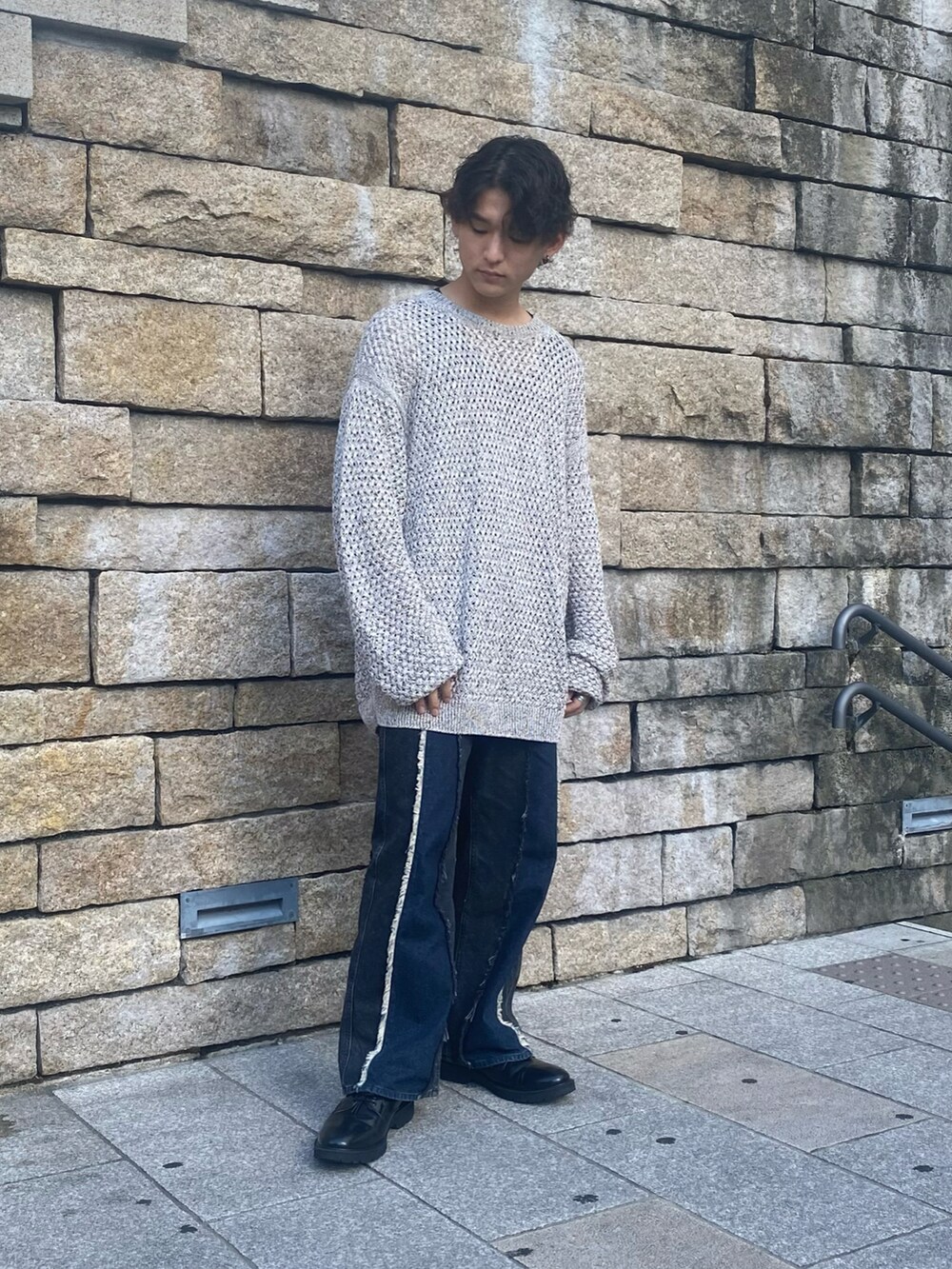 ホワイト系のニット/セーター、ブラック系のデニムパンツ、ブラック系のブーツを着用したメンズの夏コーディネートの2枚目の写真