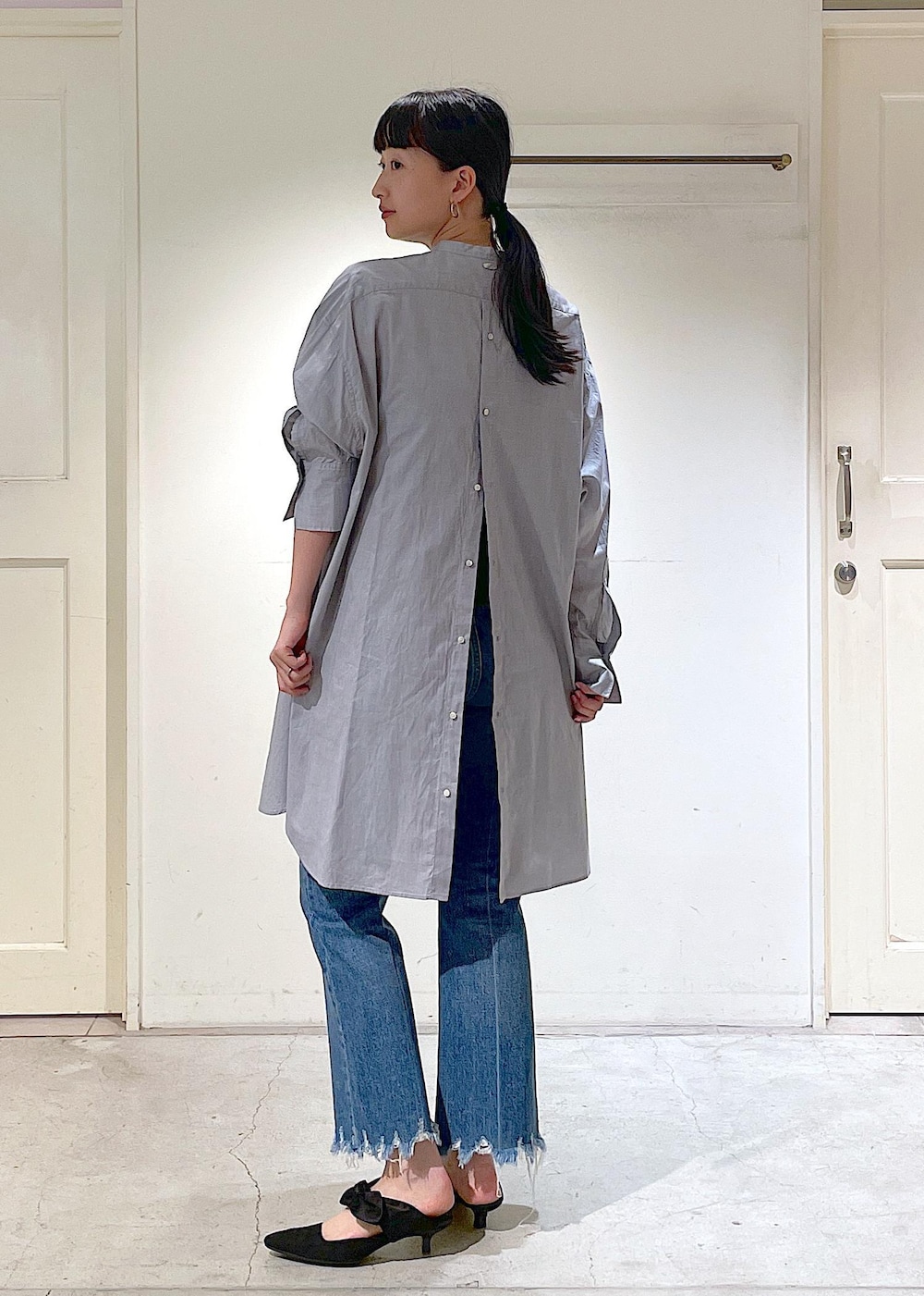 ブルー系のデニムパンツ、グレー系のシャツ/ブラウス、ホワイト系のトートバッグを着用したレディースの夏コーディネートの4枚目の写真