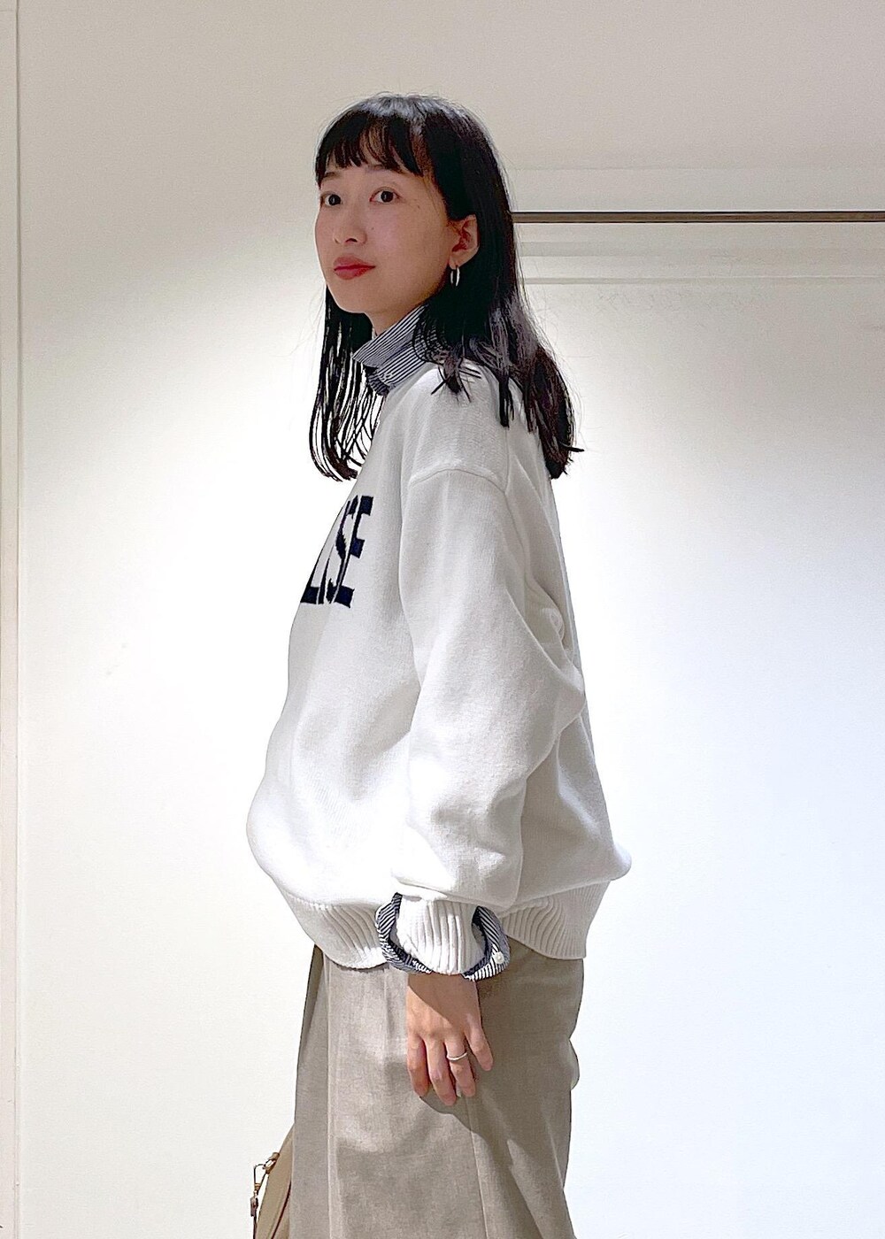 ホワイト系のその他シューズ、ブルー系のシャツ/ブラウス、ベージュ系のスラックスを着用したレディースの冬コーディネートの5枚目の写真