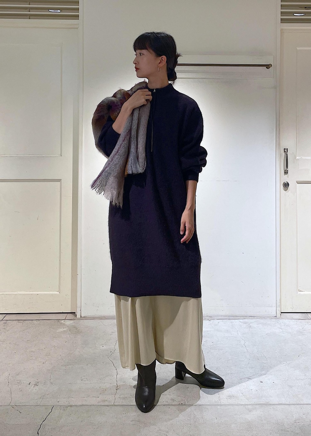 ブラック系のショルダーバッグ、ベージュ系のスカート、レッド系のワンピースを着用したレディースの秋コーディネートの2枚目の写真