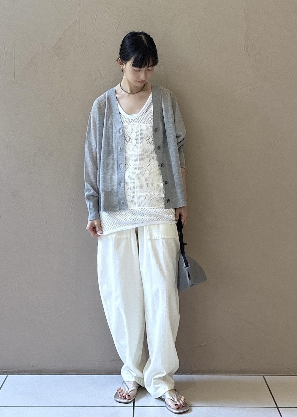 シルバー系のサンダル、グレー系のカーディガン/ボレロ、ホワイト系のその他パンツを着用したレディースの夏コーディネートの2枚目の写真