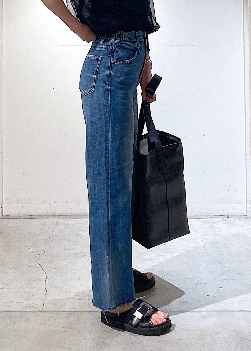 ブラック系のサンダル、ブラック系のトートバッグ、ブラック系のTシャツ/カットソーを着用したレディースの春コーディネートの6枚目の写真