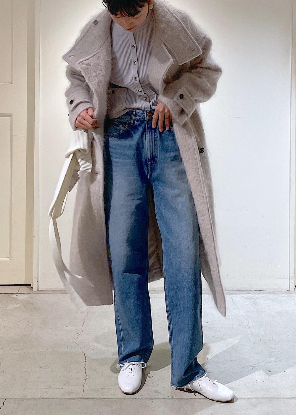 グレー系のその他アウター、ブルー系のデニムパンツ、ホワイト系のその他シューズを着用したレディースの冬コーディネートの4枚目の写真