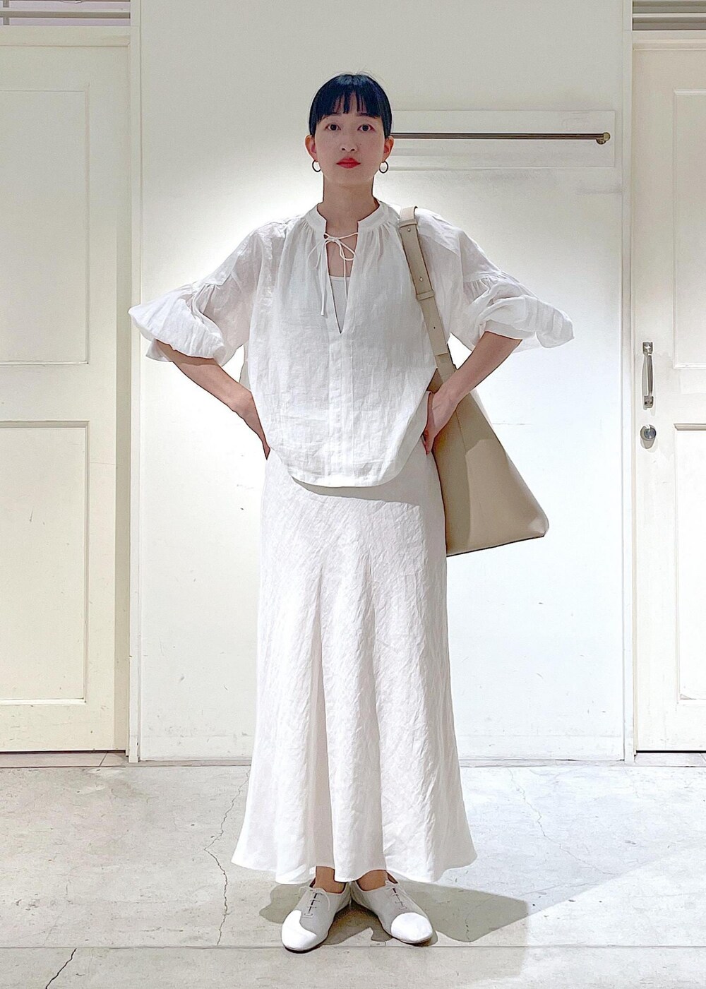 ホワイト系のその他シューズ、ホワイト系のシャツ/ブラウス、ベージュ系のトートバッグを着用したレディースの春コーディネートの2枚目の写真