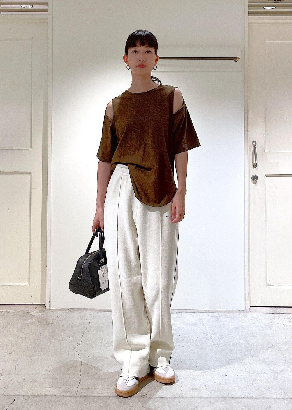 ブラウン系のTシャツ/カットソー、ホワイト系のその他パンツ、ブラック系のボストンバッグを着用したレディースの夏コーディネートの2枚目の写真