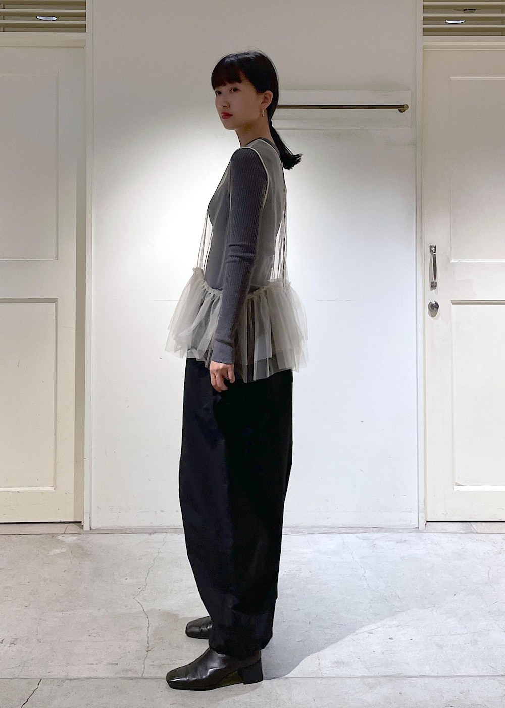 ブラック系のショルダーバッグ、ブラック系のカーゴパンツ、ホワイト系のベストを着用したレディースの秋コーディネートの4枚目の写真