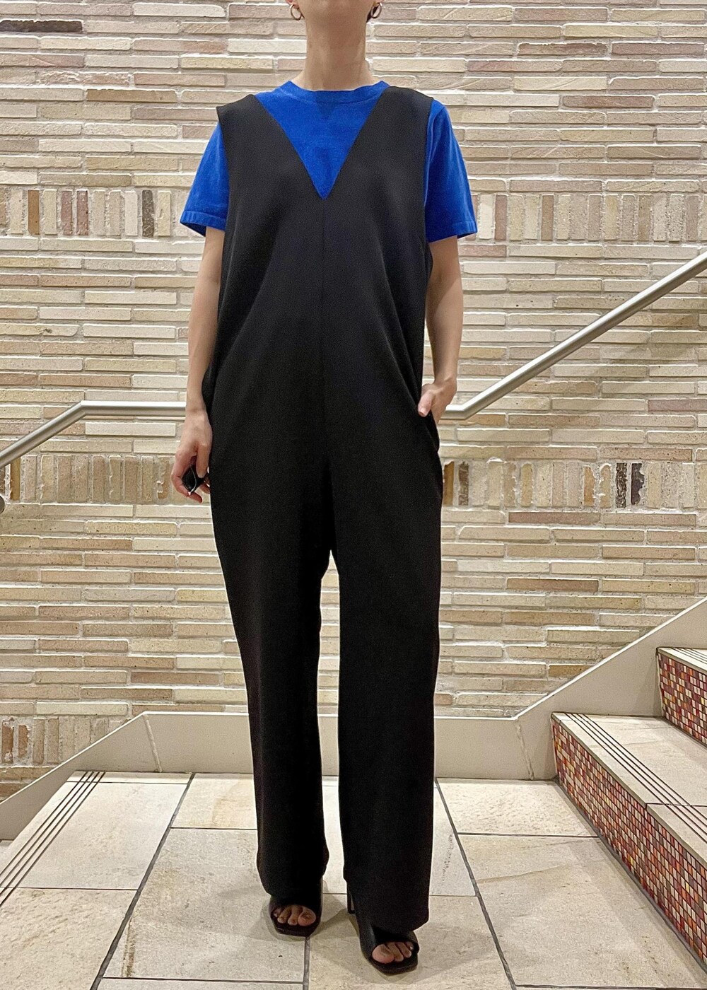 ブラック系のサンダル、ブラック系のつなぎ/オールインワン、ブルー系のTシャツ/カットソーを着用したレディースの春コーディネートの5枚目の写真