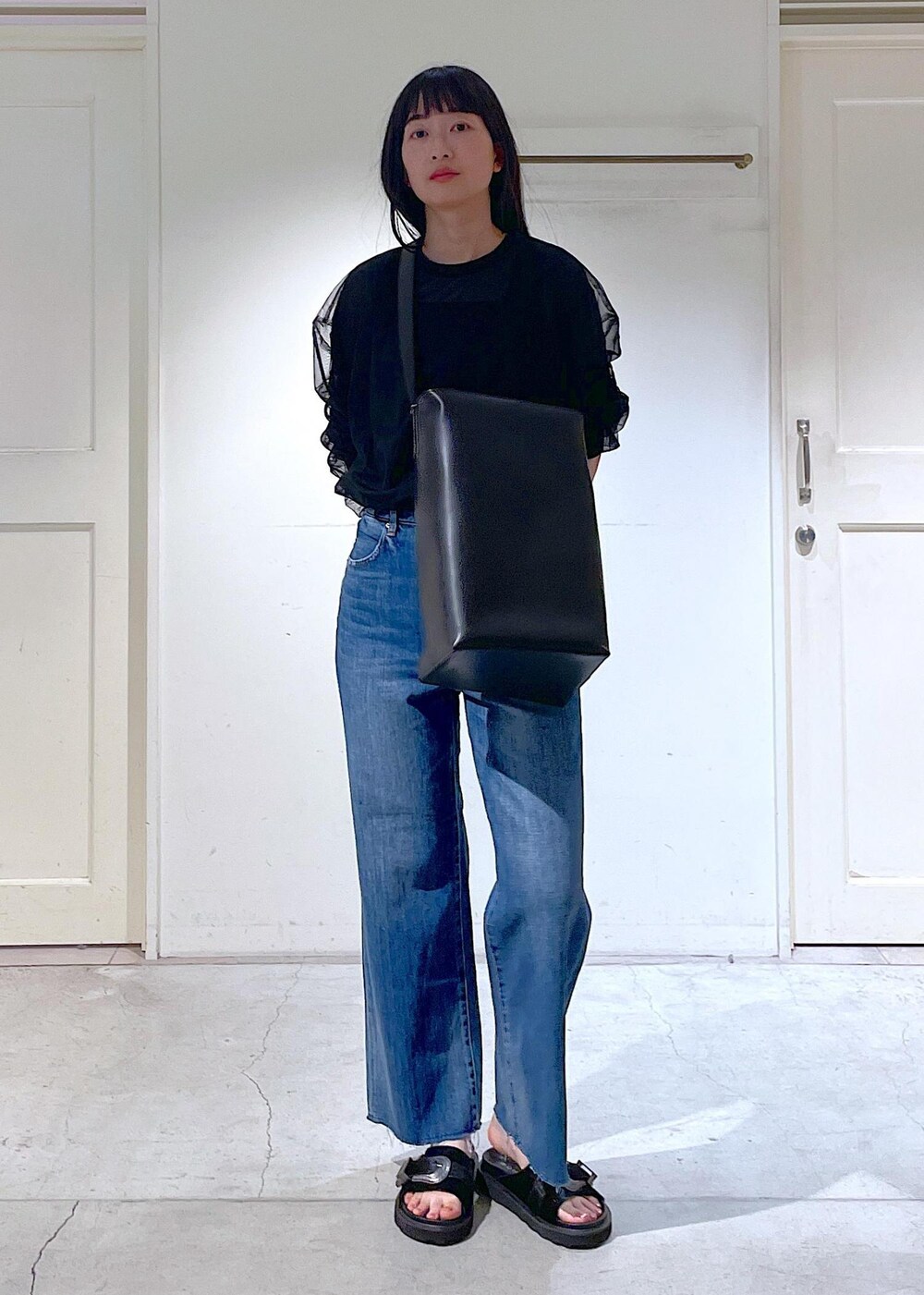 ブラック系のサンダル、ブラック系のトートバッグ、ブラック系のTシャツ/カットソーを着用したレディースの春コーディネートの7枚目の写真