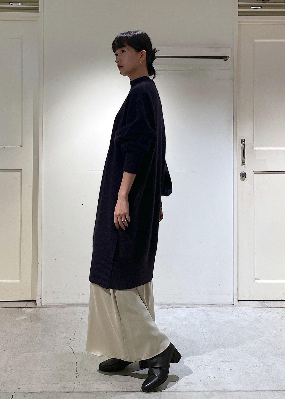 ブラック系のショルダーバッグ、ベージュ系のスカート、レッド系のワンピースを着用したレディースの秋コーディネートの3枚目の写真