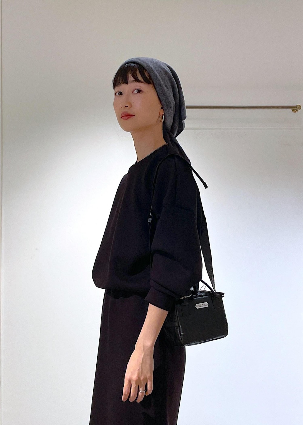 ブルー系のピーコート、ブラック系のブーツ、ブラック系のスカートを着用したレディースの秋コーディネートの6枚目の写真