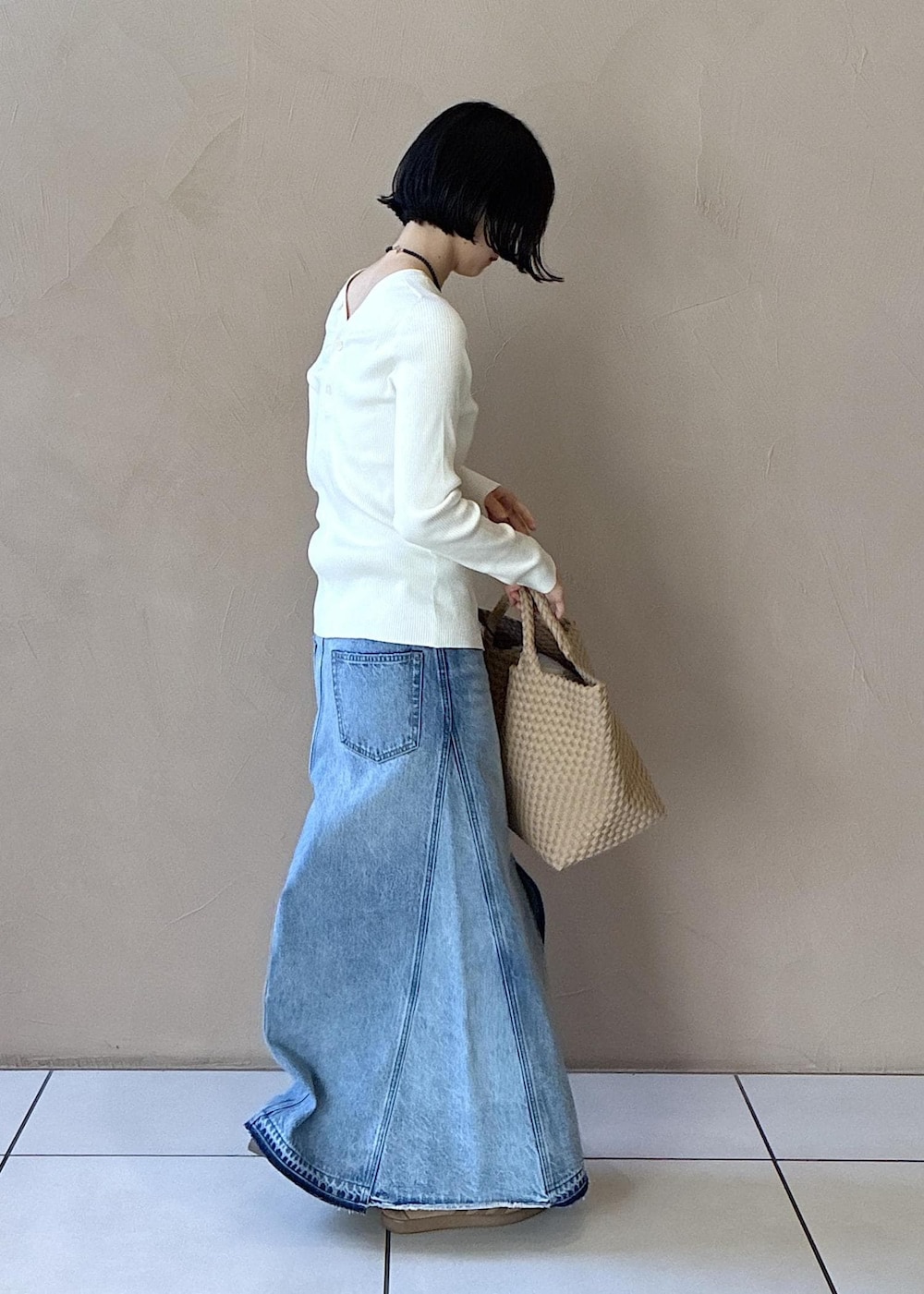 ホワイト系のカーディガン/ボレロ、イエロー系のスニーカー、ブルー系のデニムスカートを着用したレディースの春コーディネートの4枚目の写真