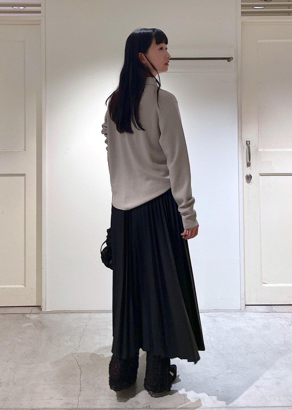 グレー系のカーディガン/ボレロ、ブラック系のスカート、ブラック系のショルダーバッグを着用したレディースの秋コーディネートの8枚目の写真