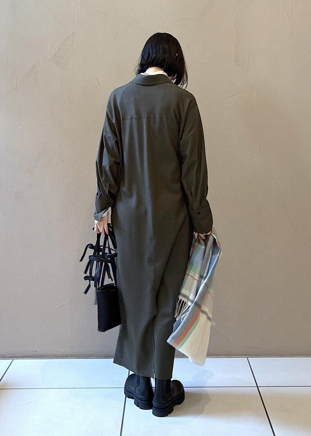 ブラック系のブーツ、グリーン系のワンピース、ホワイト系のニット/セーターを着用したレディースの冬コーディネートの4枚目の写真