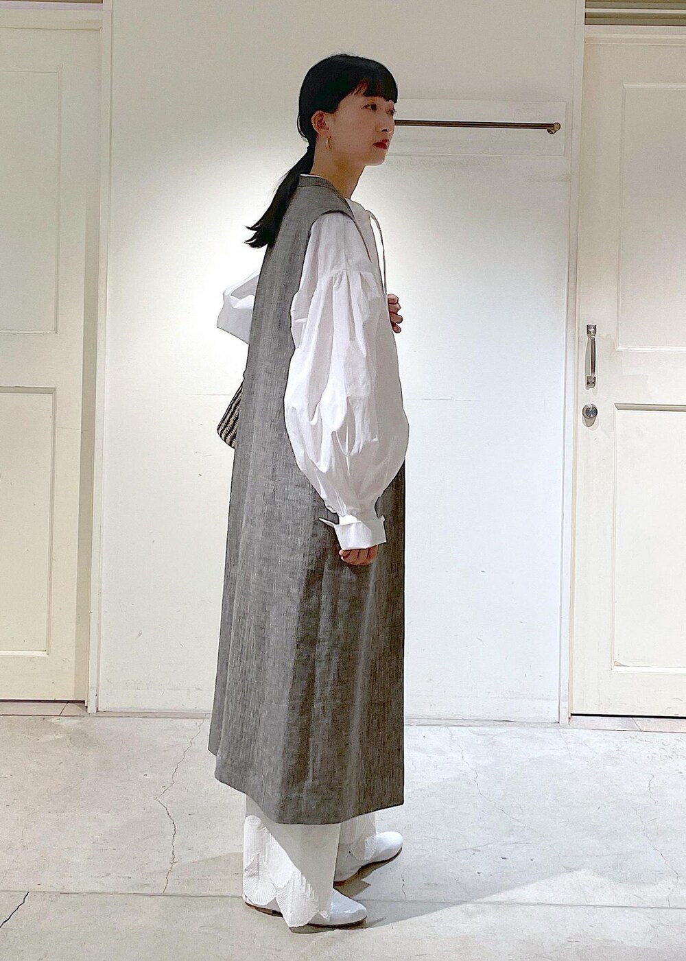 ホワイト系のシャツ/ブラウス、ホワイト系のその他シューズ、ブラック系のジャンパースカートを着用したレディースの冬コーディネートの5枚目の写真