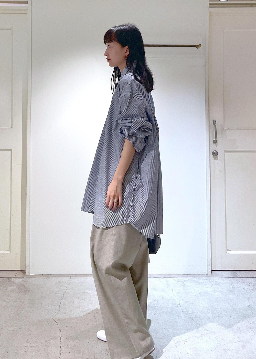 ホワイト系のその他シューズ、ブルー系のシャツ/ブラウス、ベージュ系のスラックスを着用したレディースの冬コーディネートの7枚目の写真