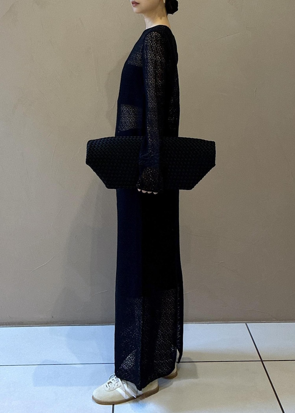 ブラック系のトートバッグ、ブラック系のワンピース、ホワイト系のスニーカーを着用したレディースの秋コーディネートの4枚目の写真