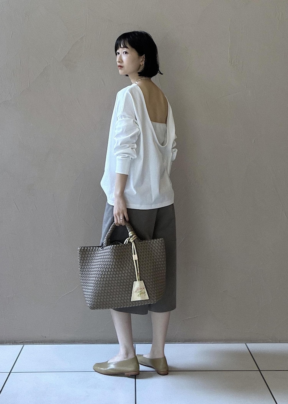 グレー系のトートバッグ、ベージュ系のその他パンツ、ベージュ系のパンプスを着用したレディースの春コーディネートの3枚目の写真