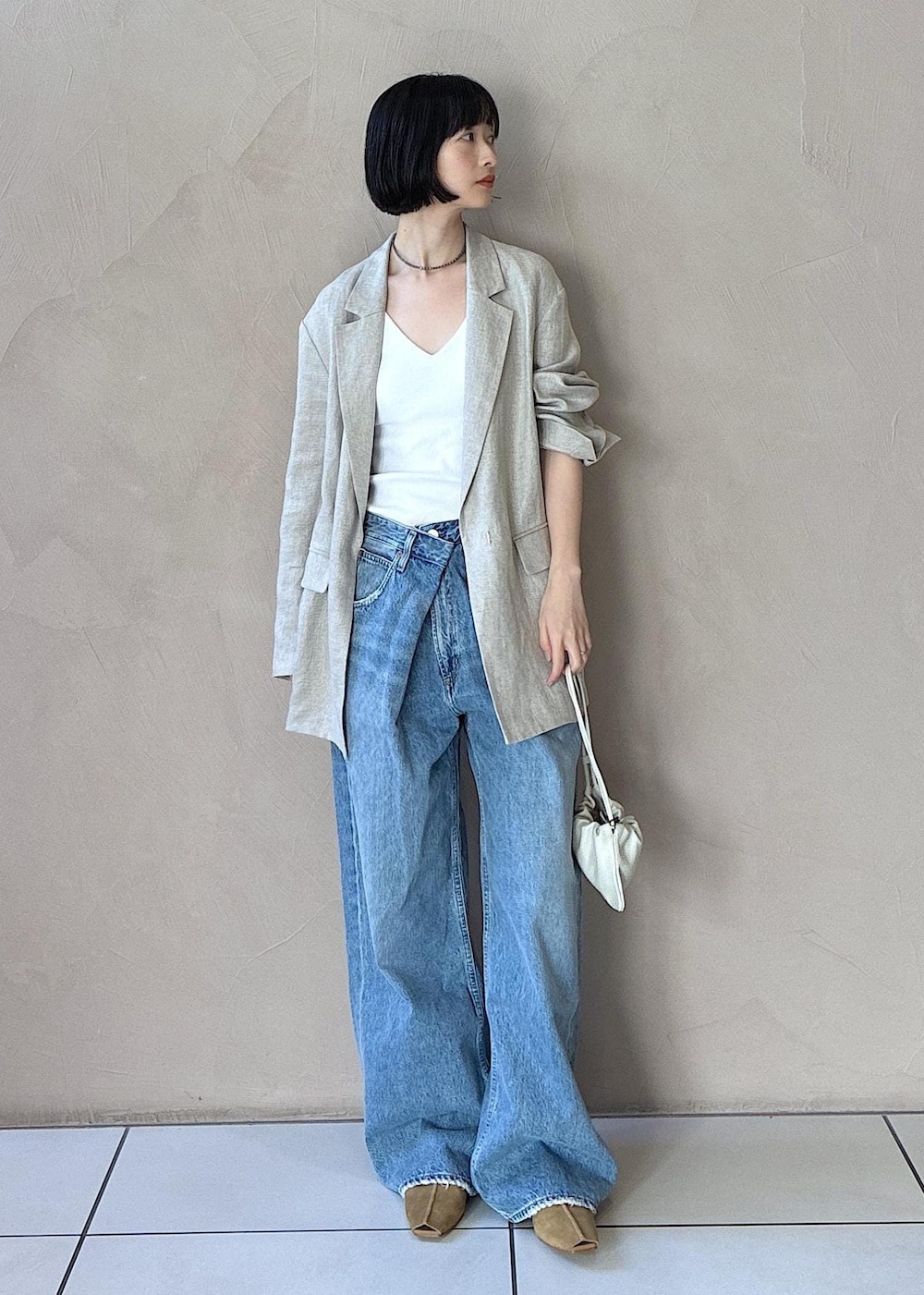 イエロー系のその他シューズ、ベージュ系のテーラードジャケット、ブルー系のデニムパンツを着用したレディースの冬コーディネートの7枚目の写真