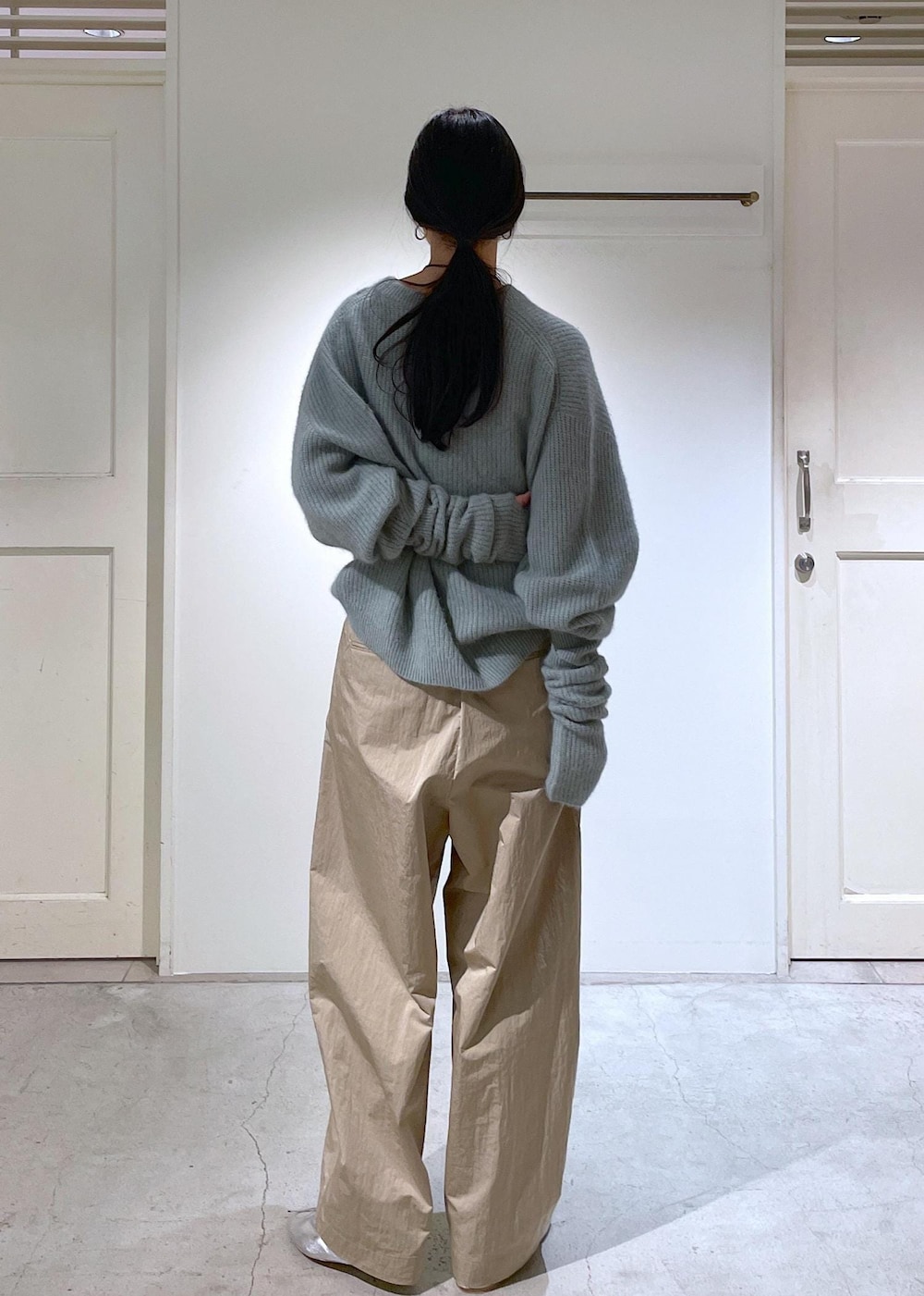 シルバー系のバレエシューズ、グレー系のショルダーバッグ、グリーン系のニット/セーターを着用したレディースの秋コーディネートの6枚目の写真