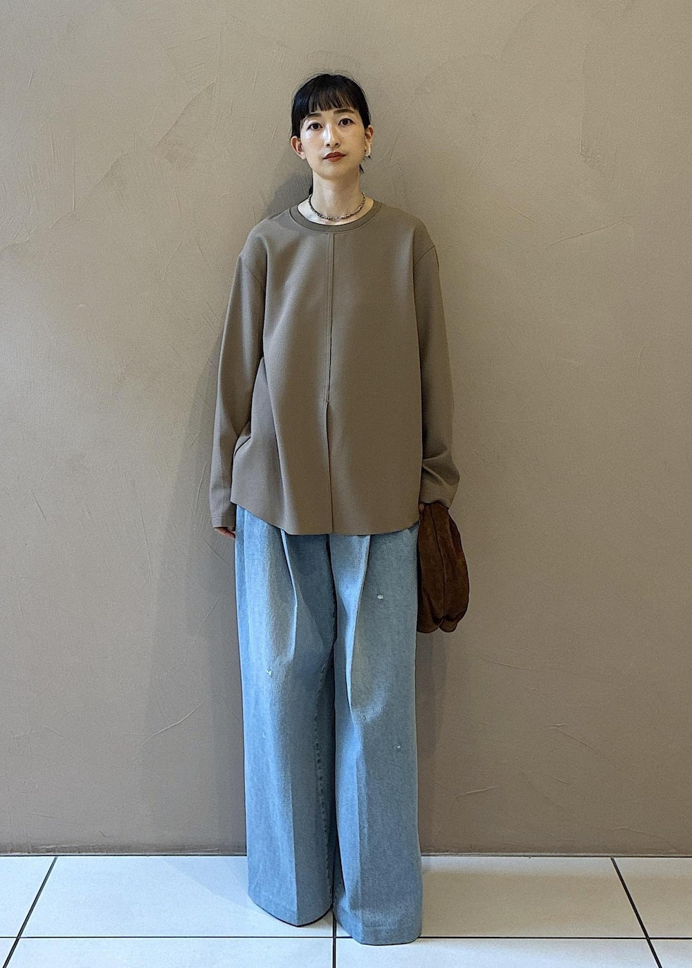 ブラウン系のハンドバッグ、ベージュ系のシャツ/ブラウス、ブラック系のその他シューズを着用したレディースの秋コーディネートの2枚目の写真