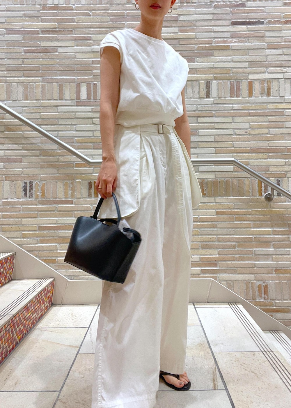 ホワイト系のTシャツ/カットソー、ホワイト系のその他パンツ、ブラック系のサンダルを着用したレディースの春コーディネートの5枚目の写真