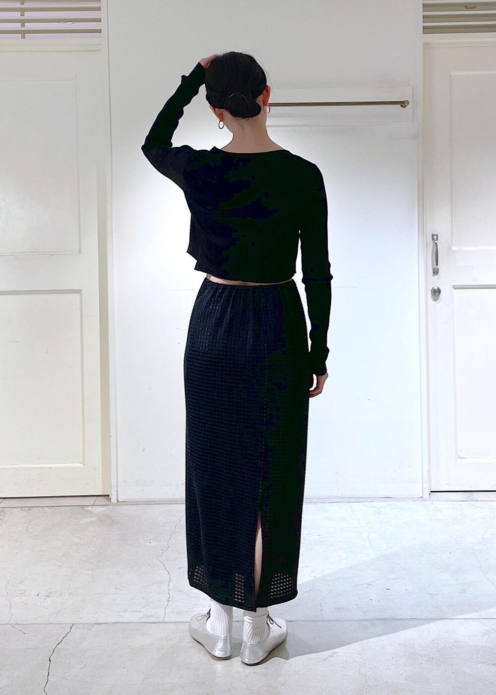 シルバー系のその他シューズ、ブラック系のスカート、ブラック系のカーディガン/ボレロを着用したレディースの冬コーディネートの3枚目の写真