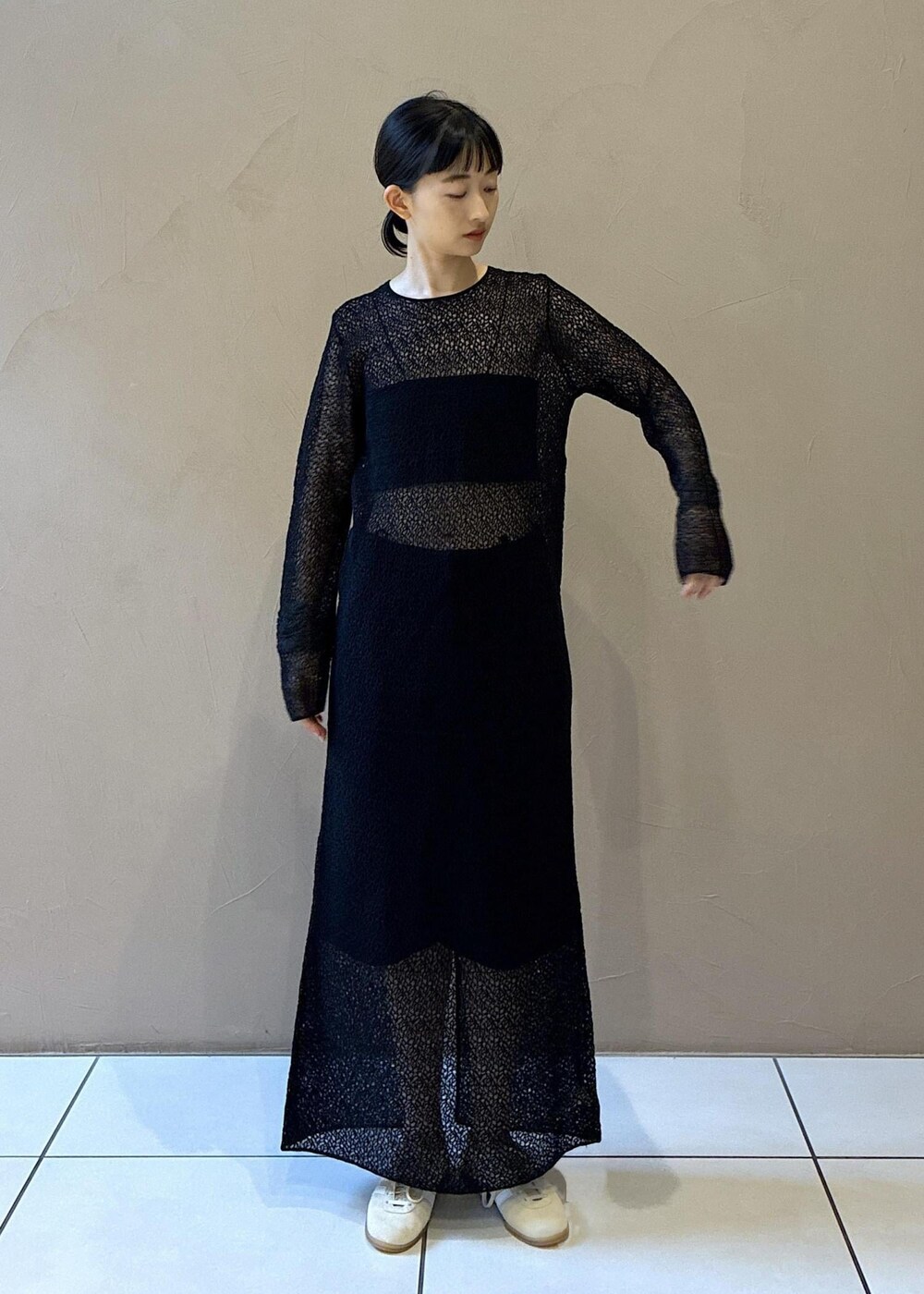 ブラック系のトートバッグ、ブラック系のワンピース、ホワイト系のスニーカーを着用したレディースの秋コーディネートの6枚目の写真