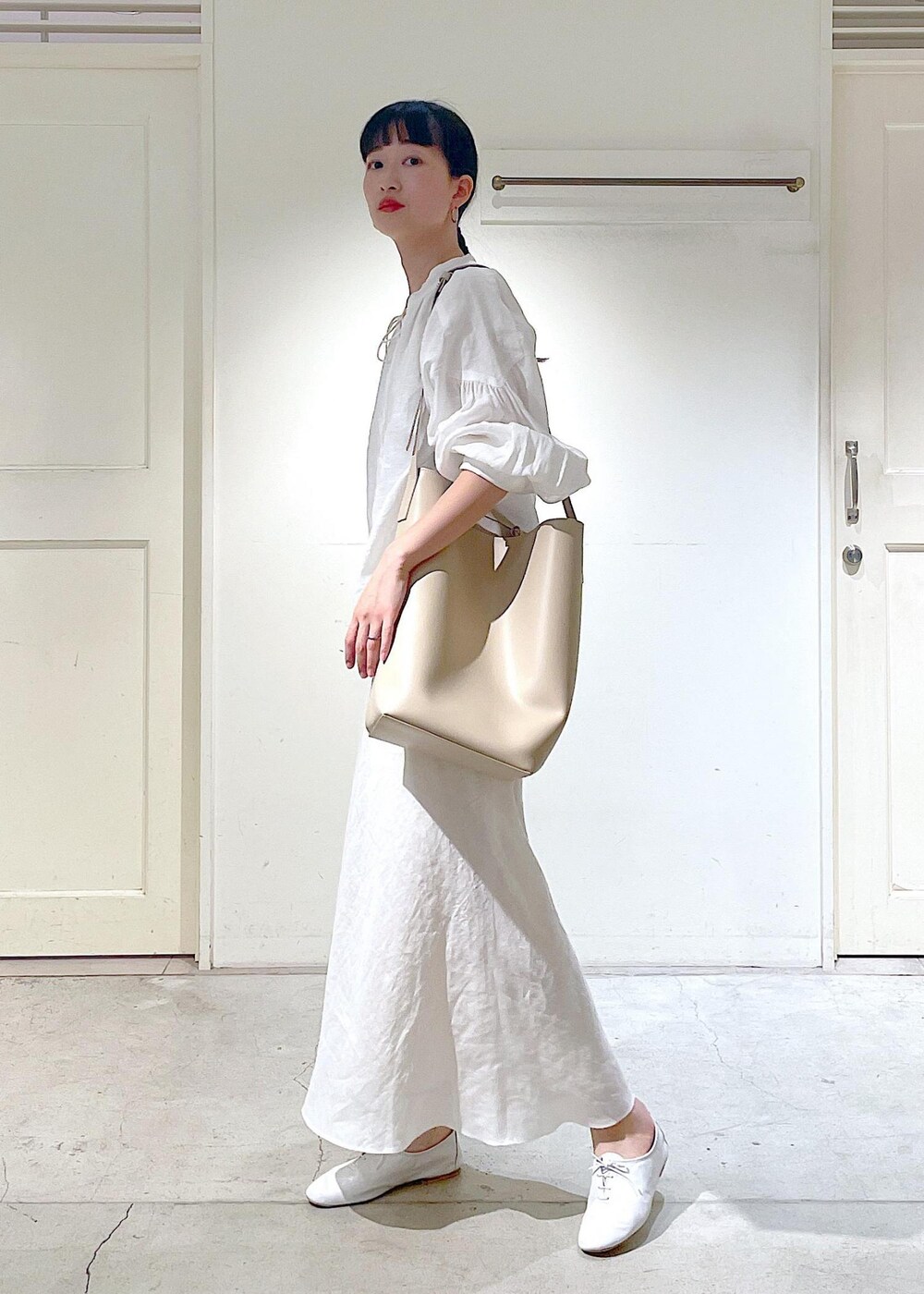 ホワイト系のその他シューズ、ホワイト系のシャツ/ブラウス、ベージュ系のトートバッグを着用したレディースの春コーディネートの4枚目の写真