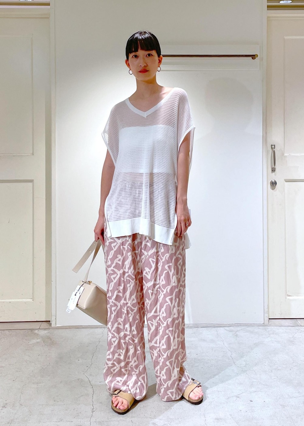 イエロー系のその他パンツ、ホワイト系のチューブトップ、ベージュ系のショルダーバッグを着用したレディースの夏コーディネートの6枚目の写真