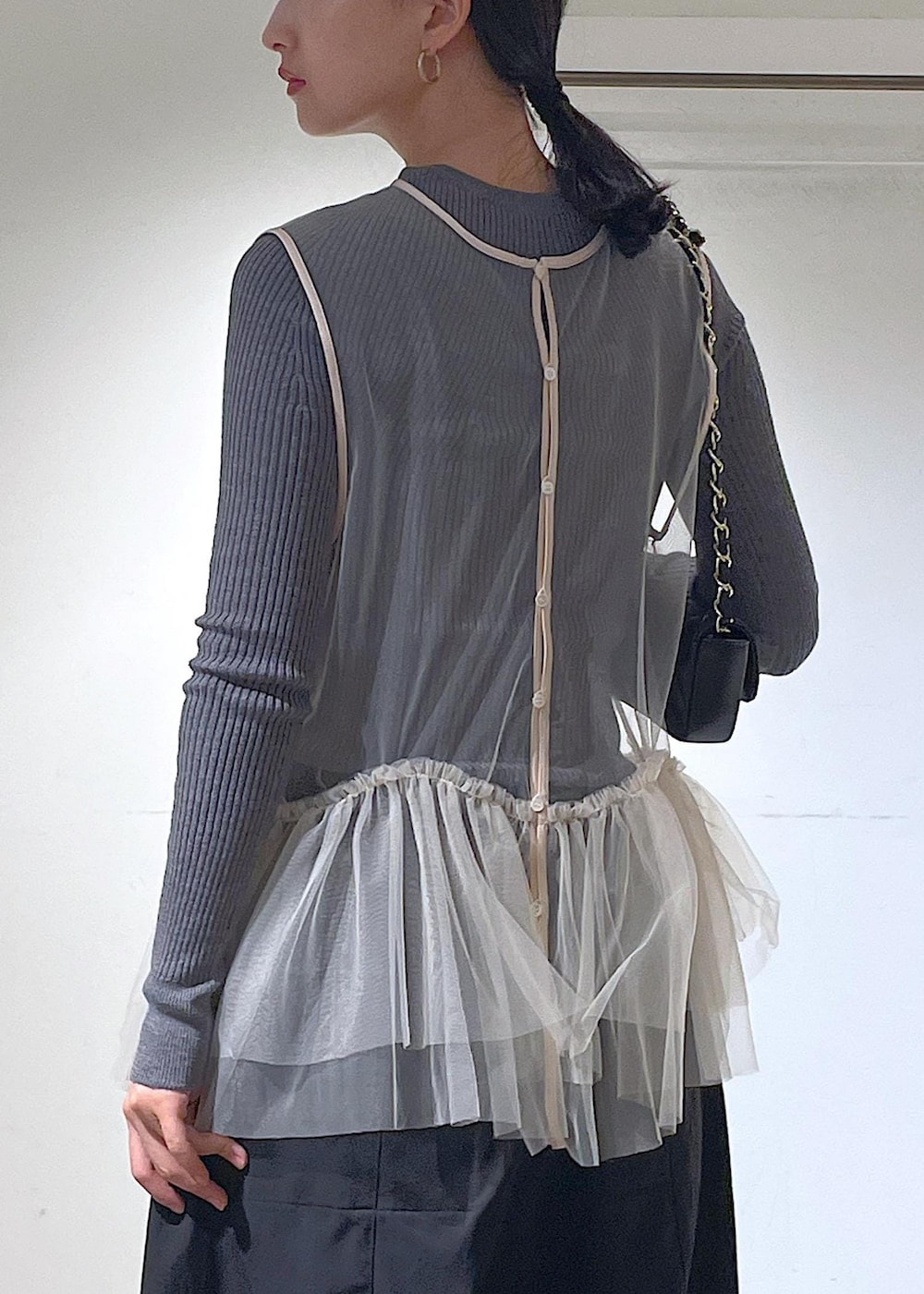 ブラック系のショルダーバッグ、ブラック系のカーゴパンツ、ホワイト系のベストを着用したレディースの秋コーディネートの6枚目の写真