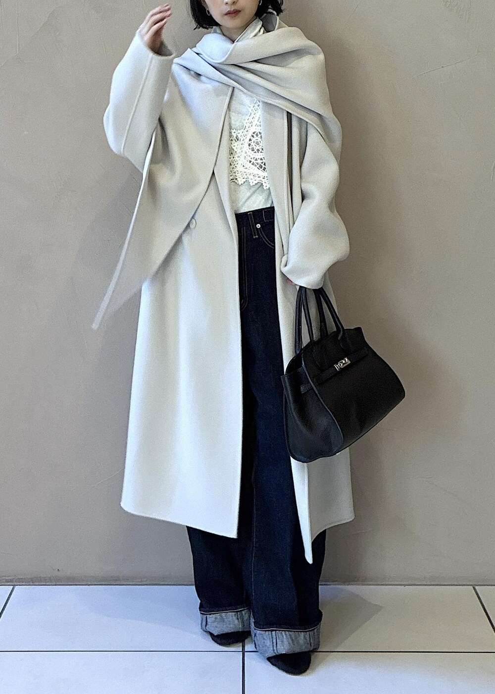 ホワイト系のその他アウター、ホワイト系のチェスターコート、ブラック系のハンドバッグを着用したレディースの秋コーディネートの7枚目の写真
