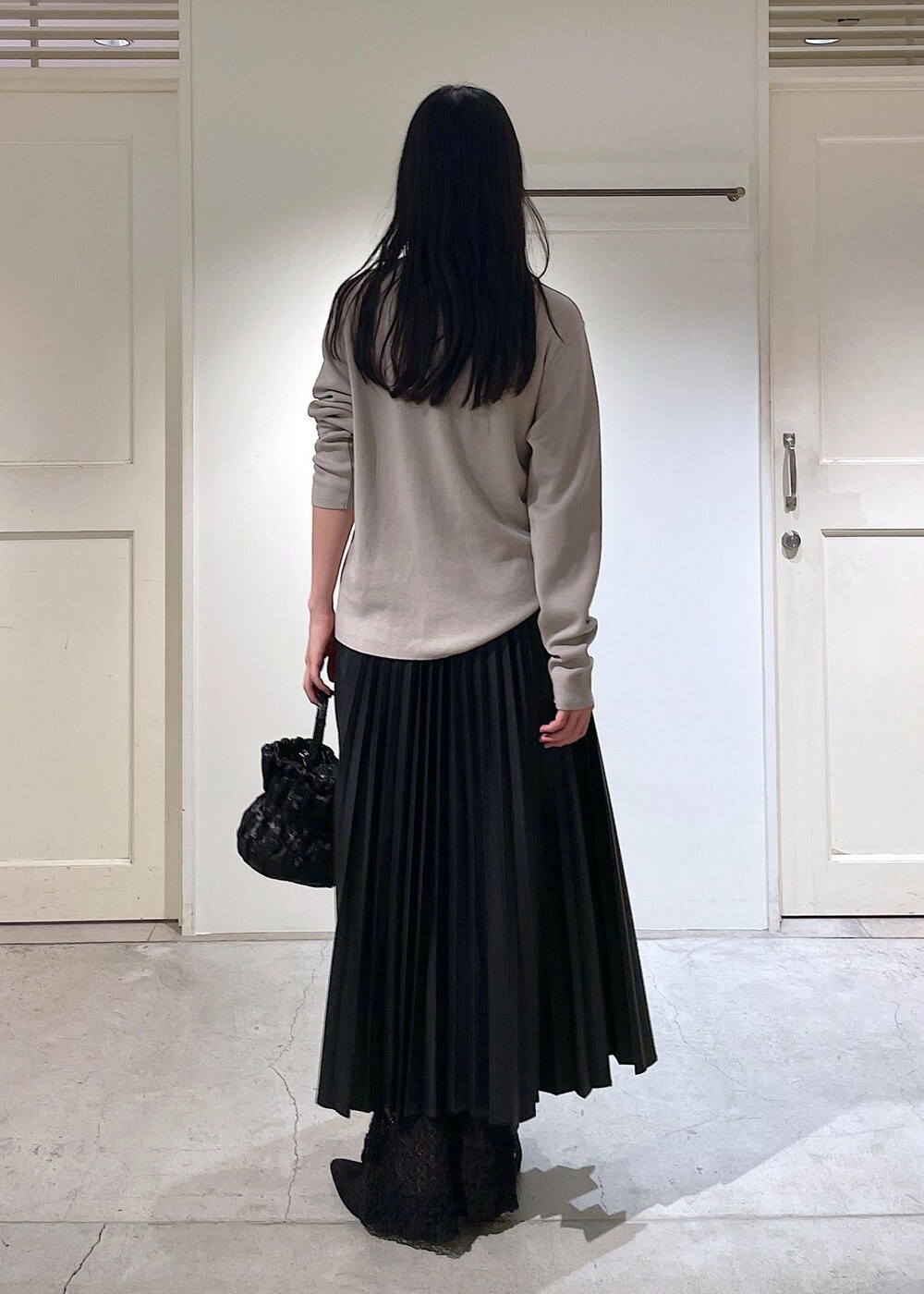 グレー系のカーディガン/ボレロ、ブラック系のスカート、ブラック系のショルダーバッグを着用したレディースの秋コーディネートの4枚目の写真