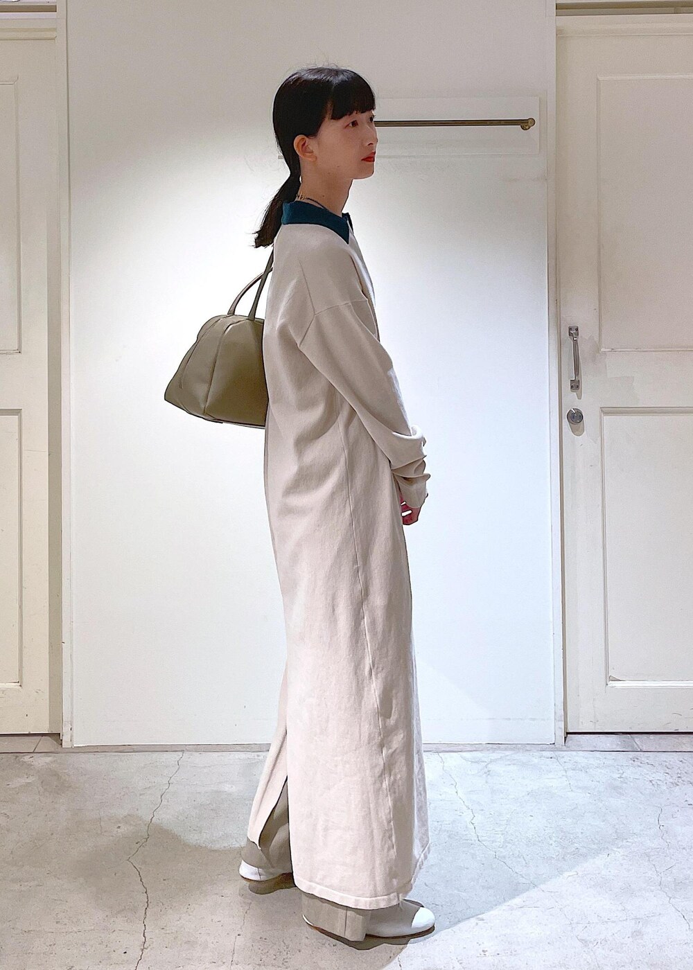 ホワイト系のその他シューズ、ベージュ系のスラックス、ホワイト系のチューブトップを着用したレディースの冬コーディネートの4枚目の写真